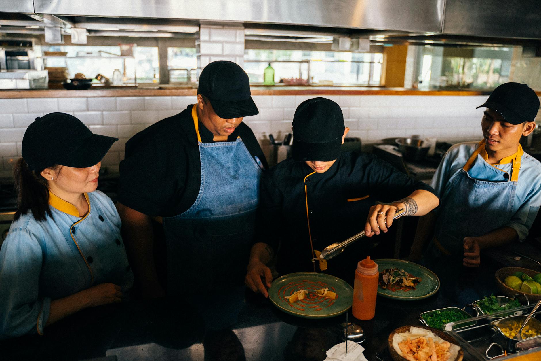 Chefs in a professional kitchen preparing and plating gourmet dishes with precision and teamwork.